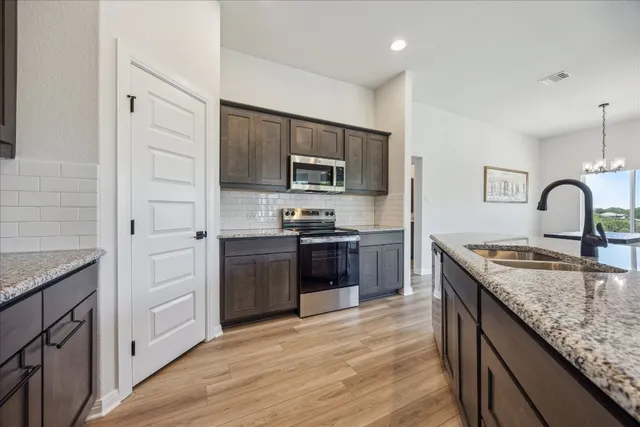 a kitchen with granite countertop stainless steel appliances and wooden cabinets