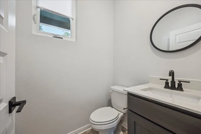 a bathroom with a sink a toilet and mirror