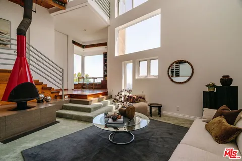 a living room with fireplace furniture and a large window
