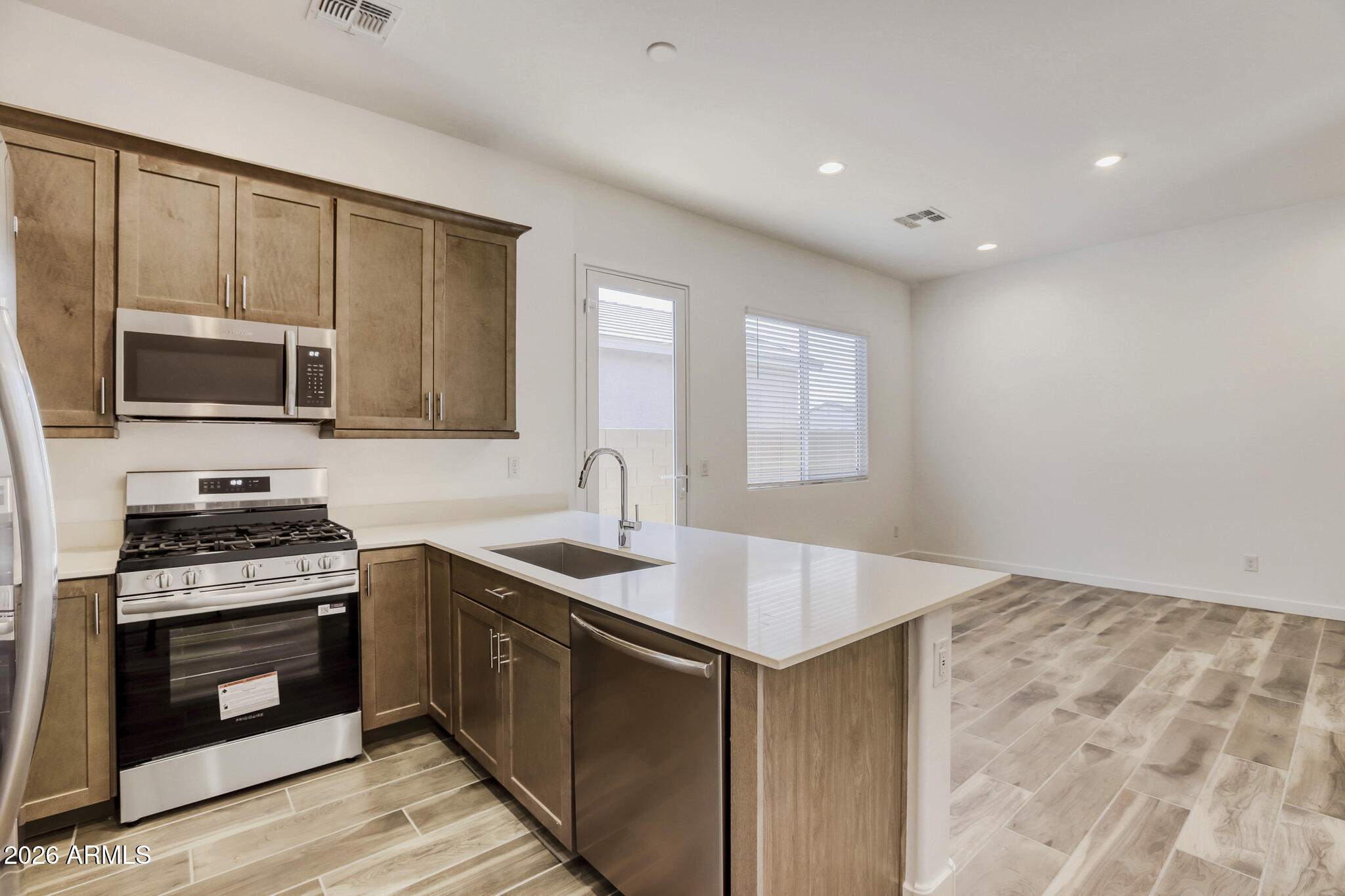 7954 West Rowel Road Peoria, AZ 85383 - Photo 17 of 31 a kitchen with stainless steel appliances granite countertop a sink stove and microwave