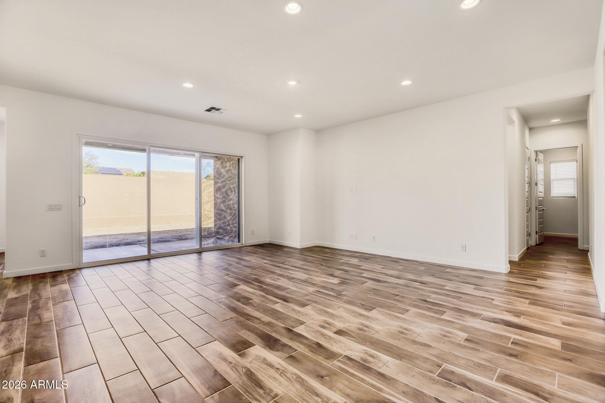 7954 West Rowel Road Peoria, AZ 85383 - Photo 8 of 31 a view of an empty room with wooden floor and a window