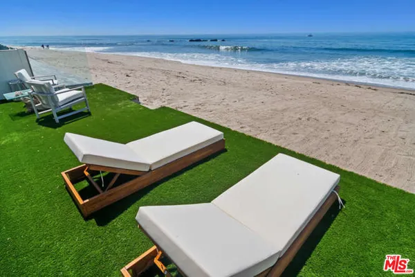 a view of a backyard with lawn chairs and a swimming pool