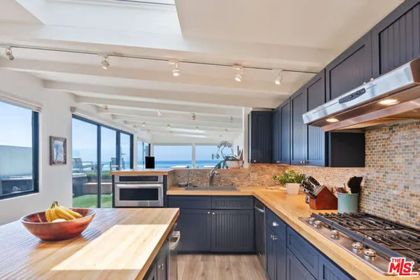 a kitchen with stainless steel appliances granite countertop a sink stove and wooden cabinets