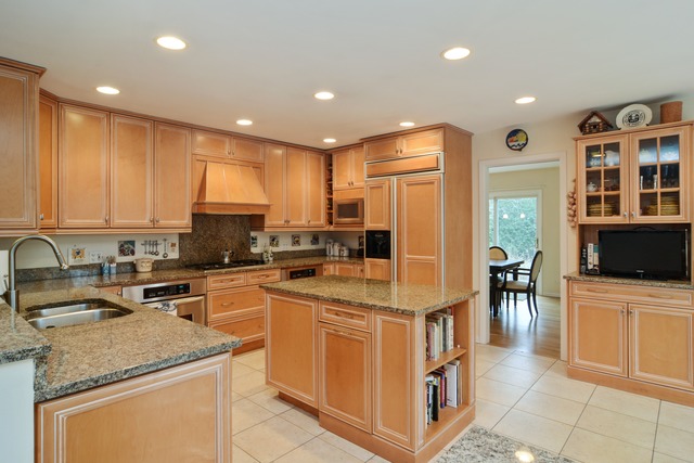 1808 Birch Road Northbrook, IL 60062 - Photo 6 of 24 a kitchen with stainless steel appliances granite countertop a stove top oven a sink a refrigerator and white cabinets with wooden floor