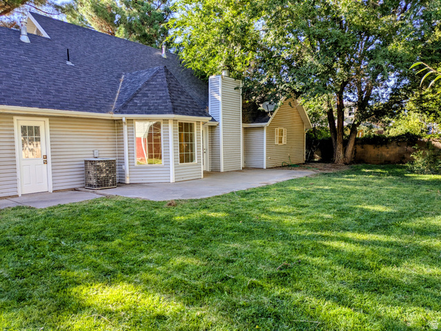 441 Main Street Hurricane, UT 84737 - Photo 7 of 29 Expansive yard featuring a concrete patio, mature trees, and a detached shed with a garage door