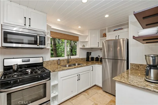 a kitchen with stainless steel appliances granite countertop a stove a refrigerator and a microwave