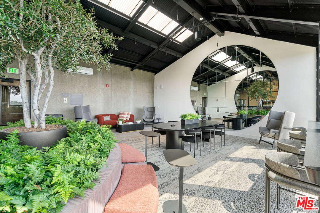 10700 Tabor Street, Unit 524 Los Angeles, CA 90034 - Photo 18 of 29 a view of a patio with table and chairs barbeque potted plants and large tree