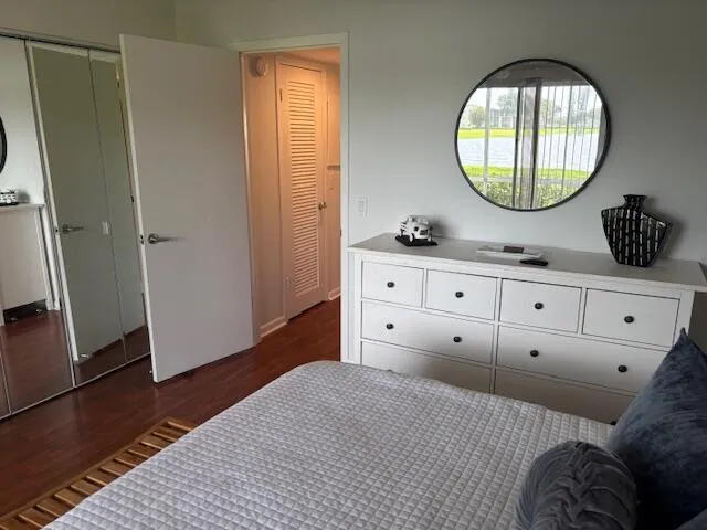 a bedroom with a large mirror and a wooden floor