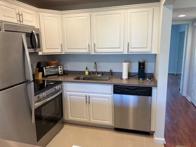 a kitchen with granite countertop white cabinets and stainless steel appliances
