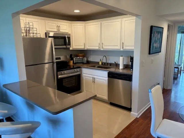 a kitchen with a refrigerator a stove a microwave and wooden floor