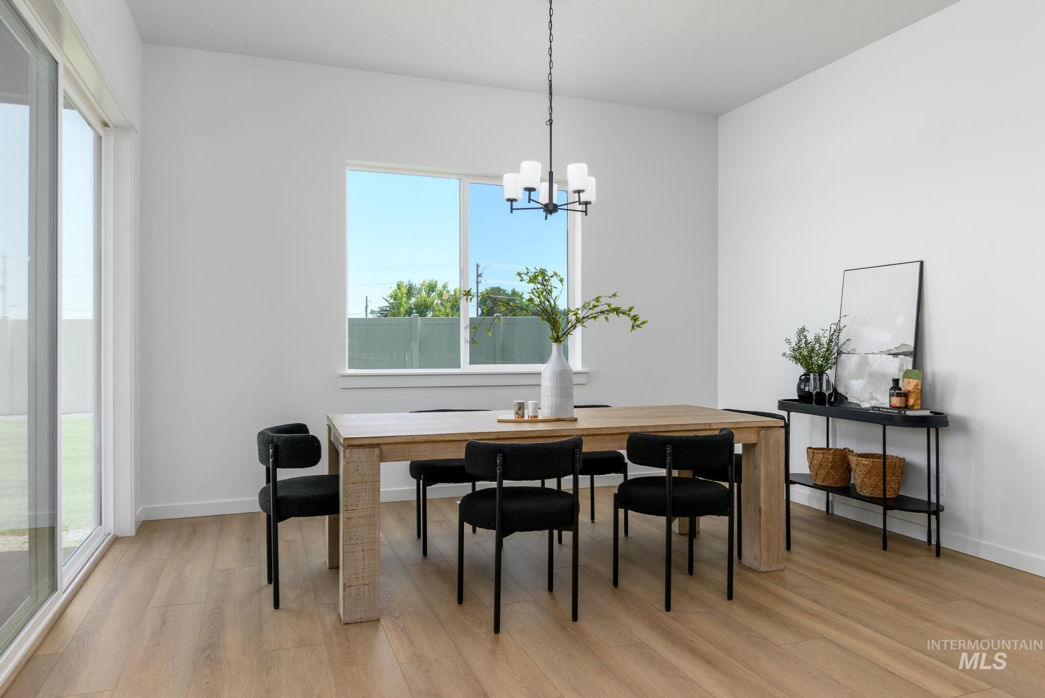 5407 Sparky Avenue Caldwell, ID 83607 - Photo 17 of 41 Dining room with light wood-style flooring and a chandelier