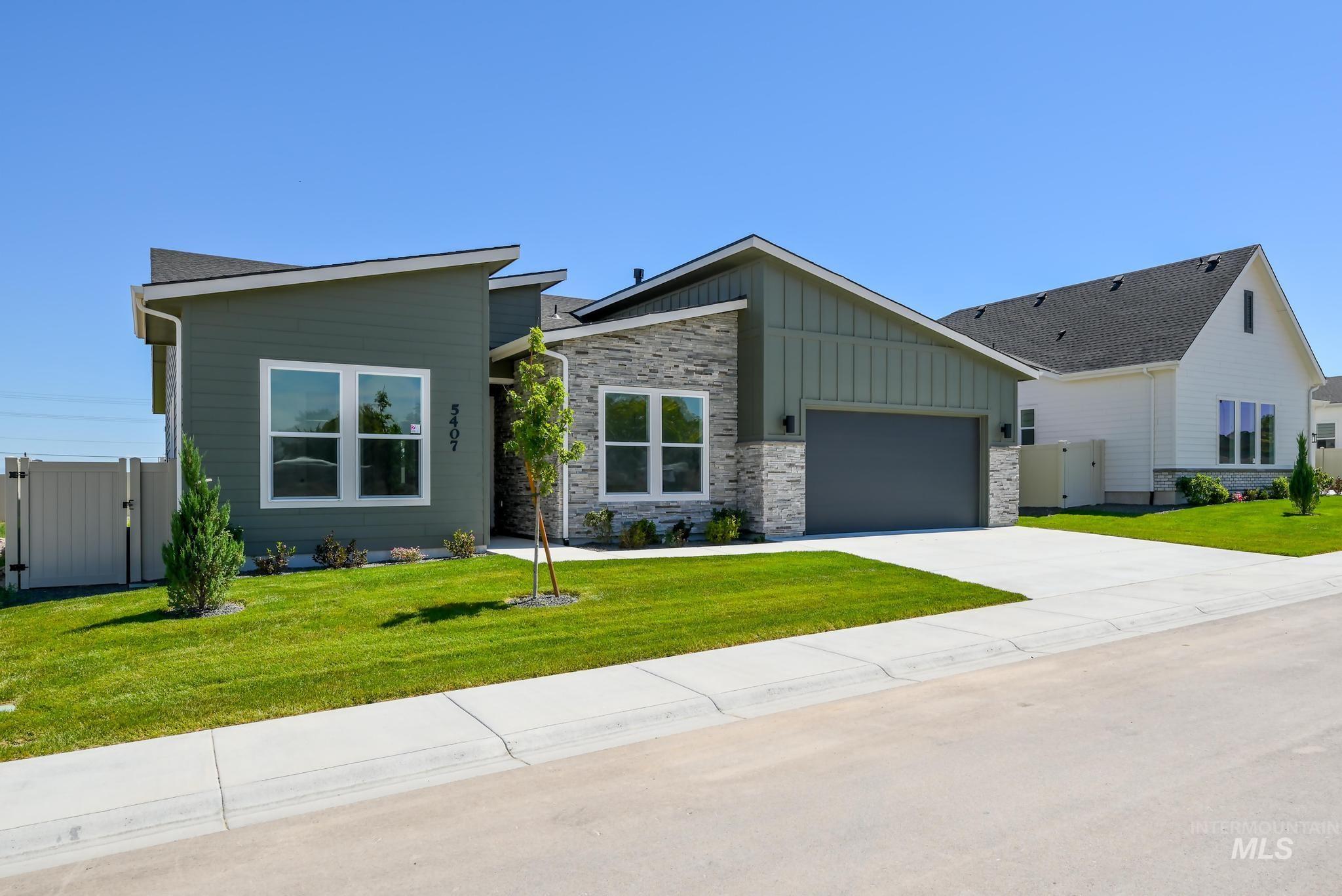 5407 Sparky Avenue Caldwell, ID 83607 - Photo 2 of 41 View of front of home featuring a gate, board and batten siding, a garage, concrete driveway, and stone siding