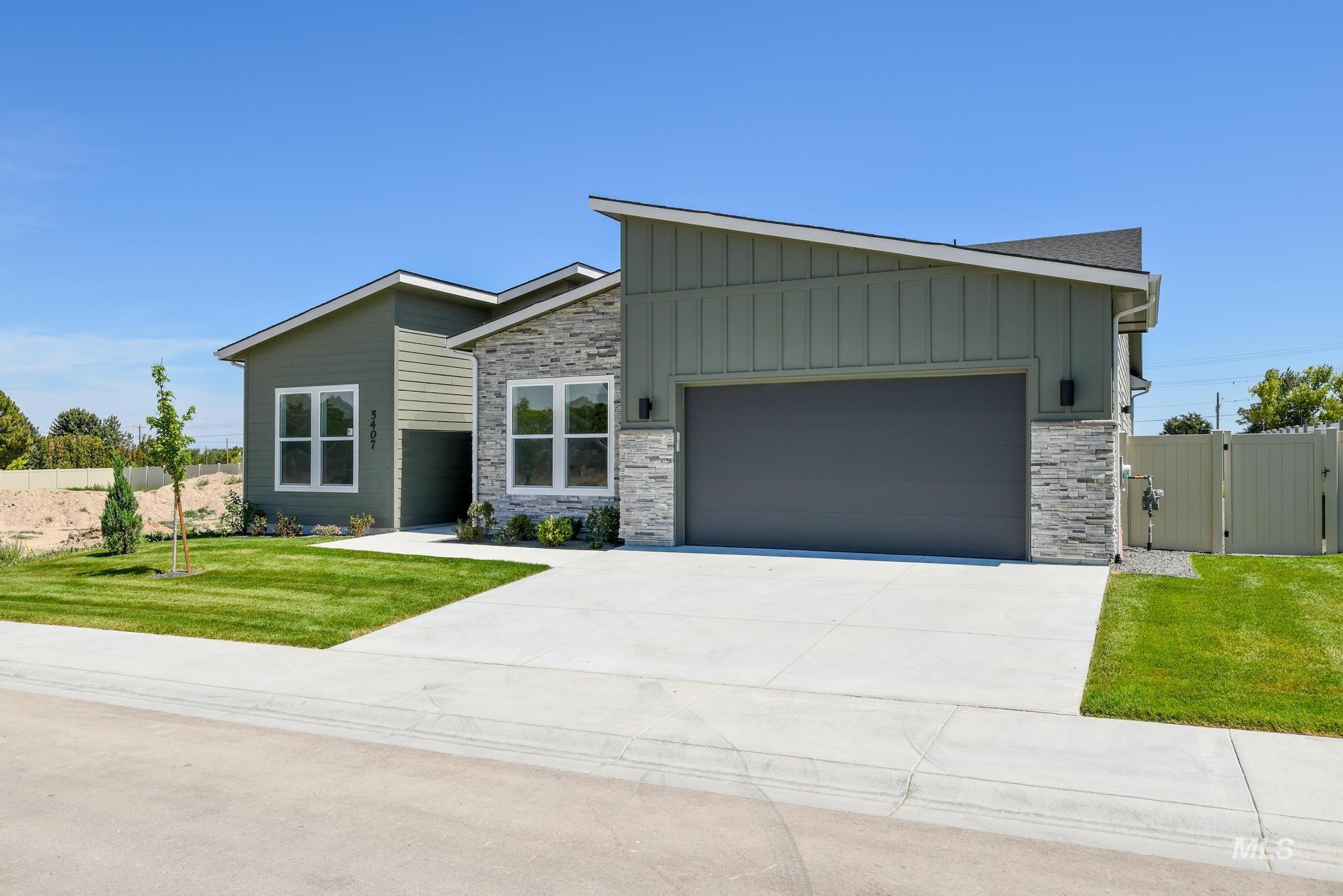 5407 Sparky Avenue Caldwell, ID 83607 - Photo 3 of 41 View of front facade featuring stone siding, board and batten siding, concrete driveway, and an attached garage
