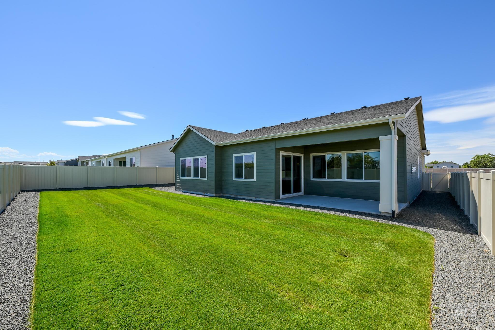 5407 Sparky Avenue Caldwell, ID 83607 - Photo 31 of 41 Rear view of house with a fenced backyard, a patio area, and a shingled roof