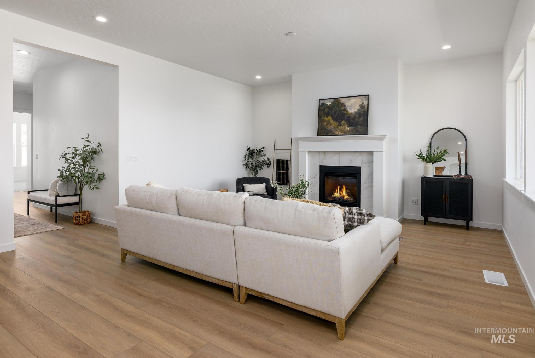 5407 Sparky Avenue Caldwell, ID 83607 - Photo 4 of 41 Living area with recessed lighting, a tiled fireplace, and light wood-type flooring