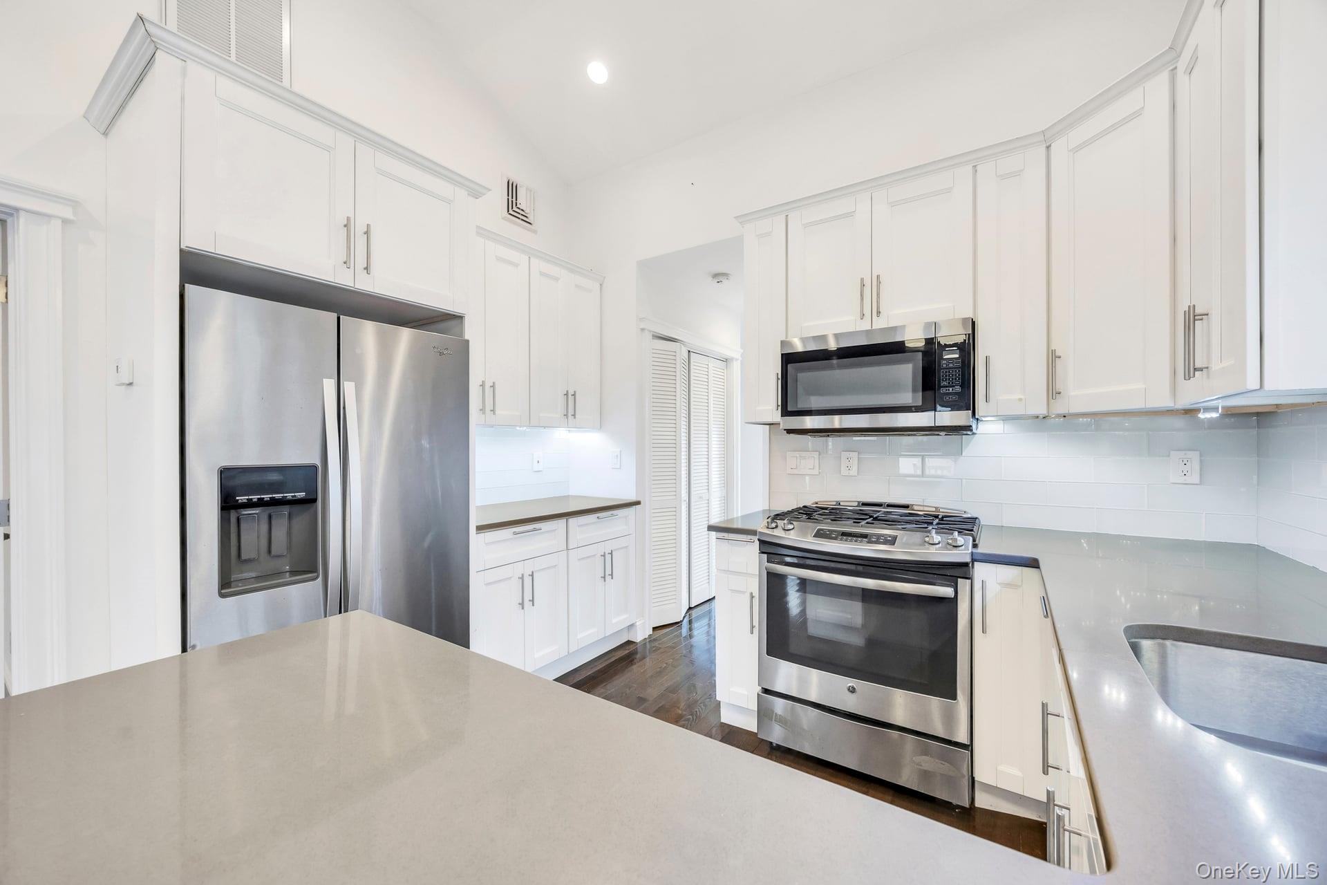 21 Ireland Place Copiague, NY 11726 - Photo 15 of 26 a kitchen with stainless steel appliances granite countertop a stove a refrigerator and a microwave