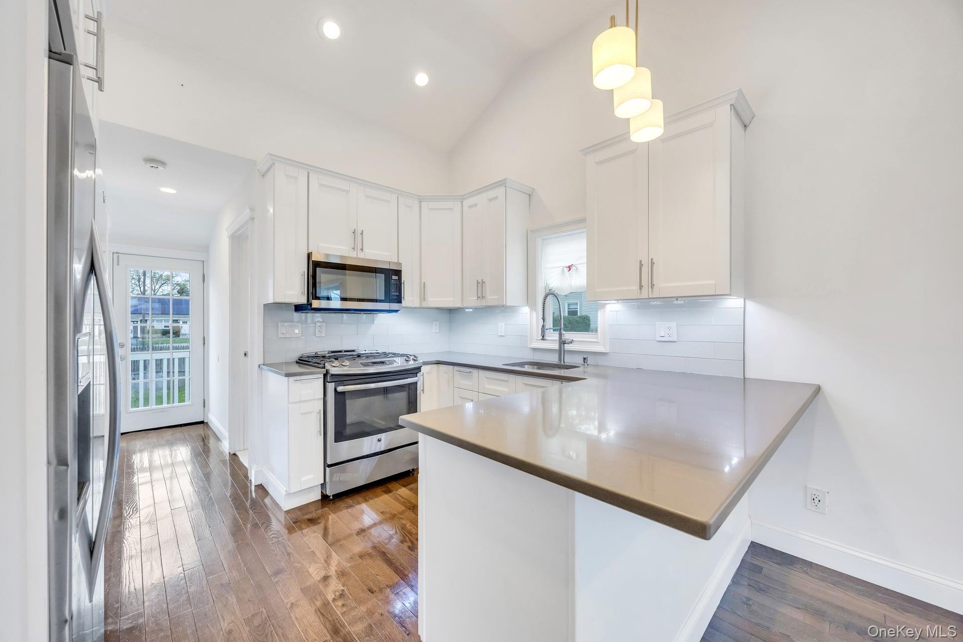 21 Ireland Place Copiague, NY 11726 - Photo 16 of 26 a kitchen with stainless steel appliances granite countertop a sink a stove top oven a counter space and cabinets