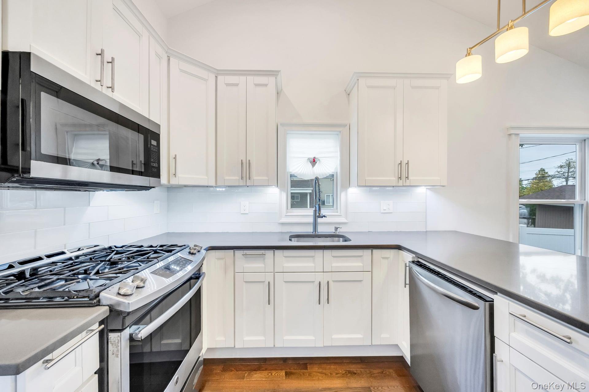 21 Ireland Place Copiague, NY 11726 - Photo 18 of 26 a kitchen with stainless steel appliances granite countertop a sink stove and microwave