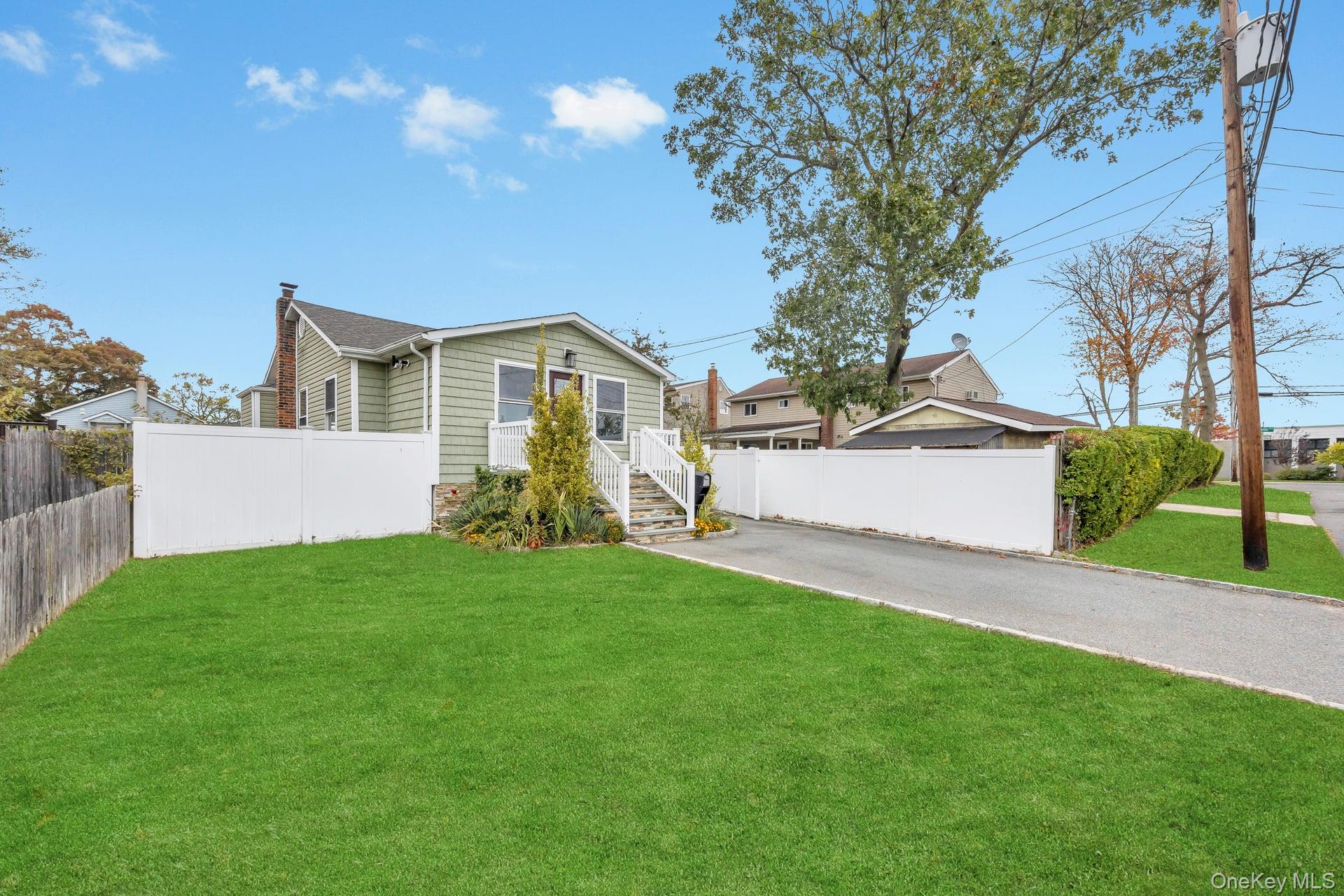 21 Ireland Place Copiague, NY 11726 - Photo 2 of 26 a view of a yard in front of a house with large trees