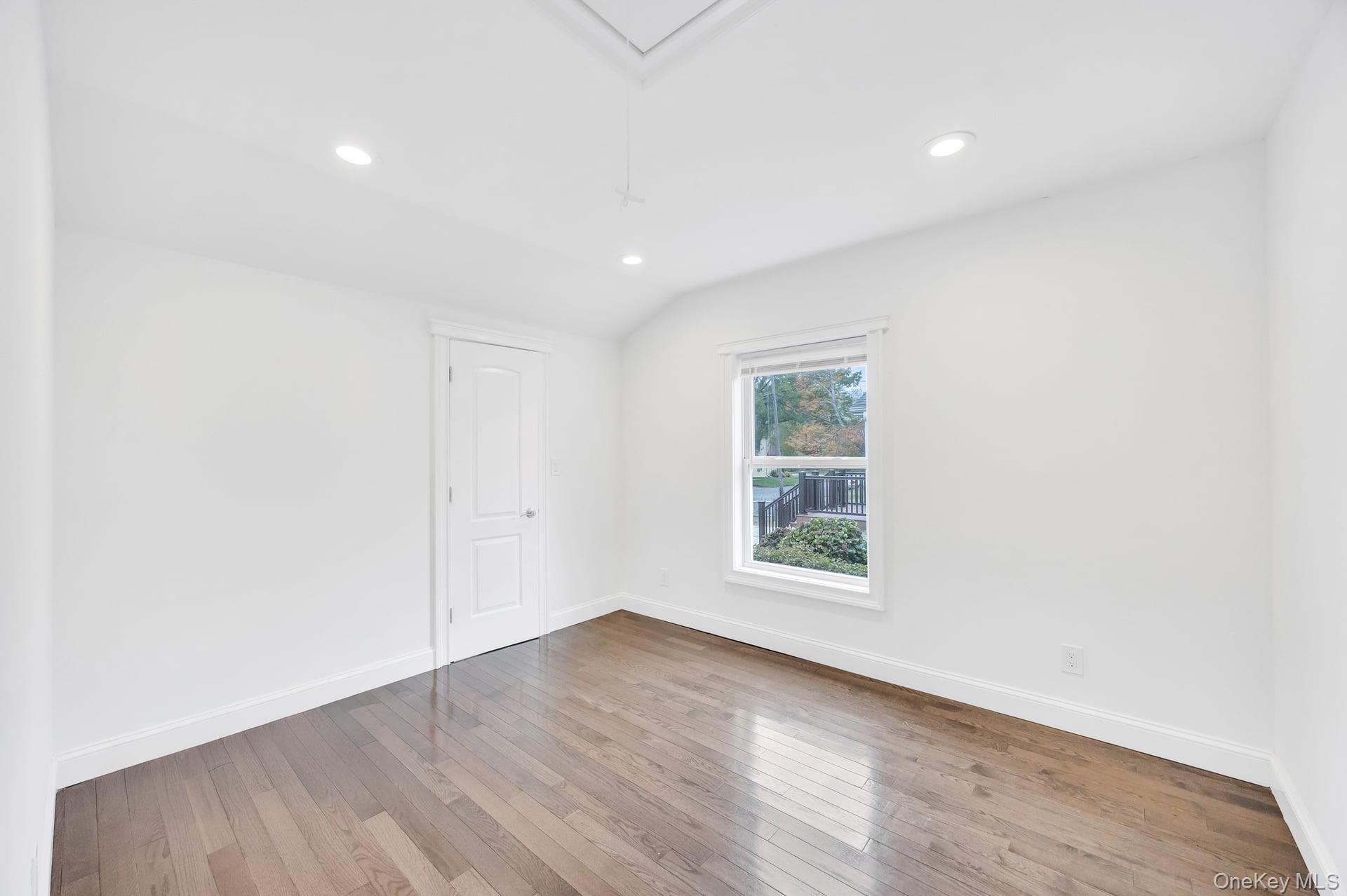 21 Ireland Place Copiague, NY 11726 - Photo 21 of 26 an empty room with wooden floor and windows