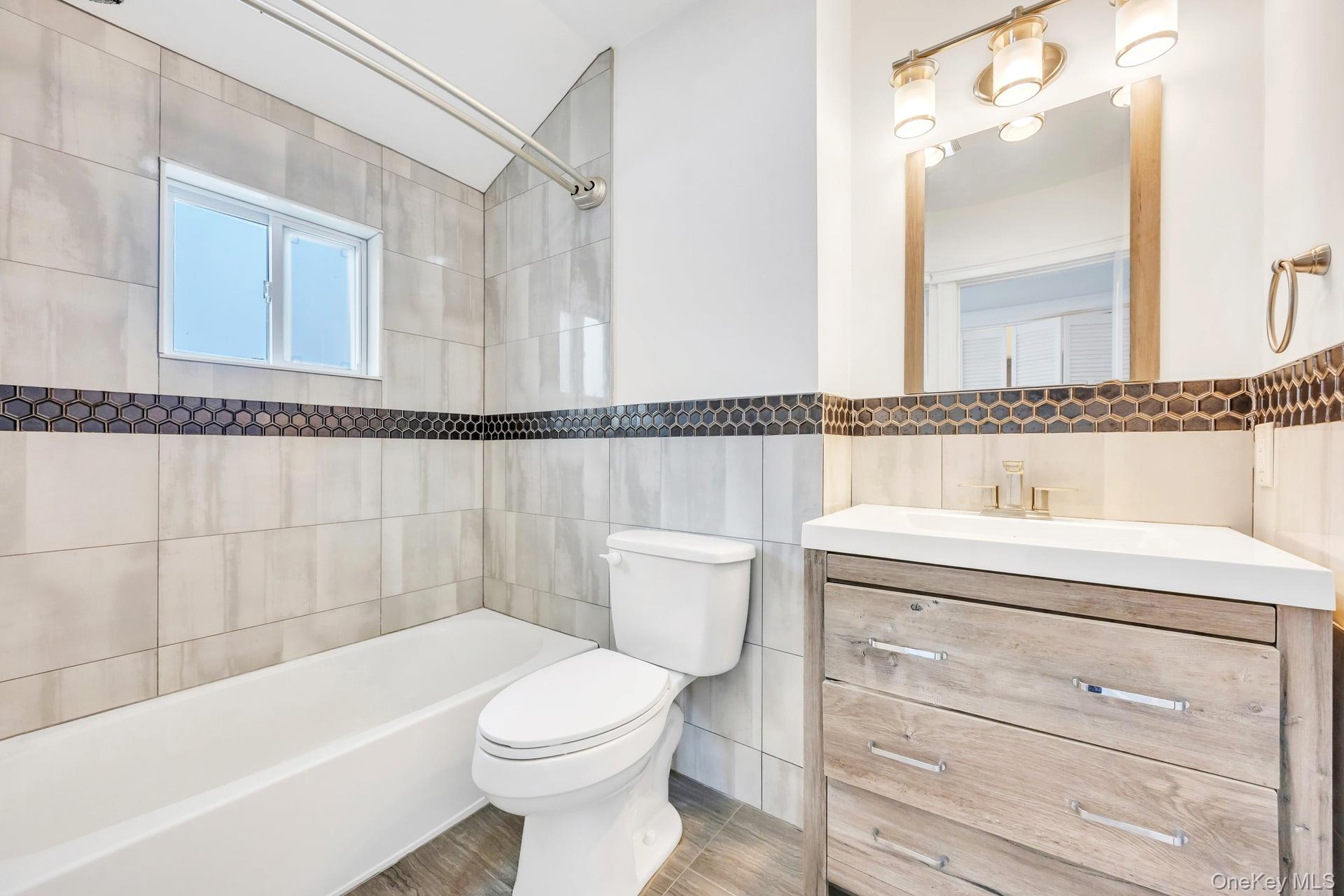 21 Ireland Place Copiague, NY 11726 - Photo 23 of 26 a bathroom with a toilet a sink and bathtub