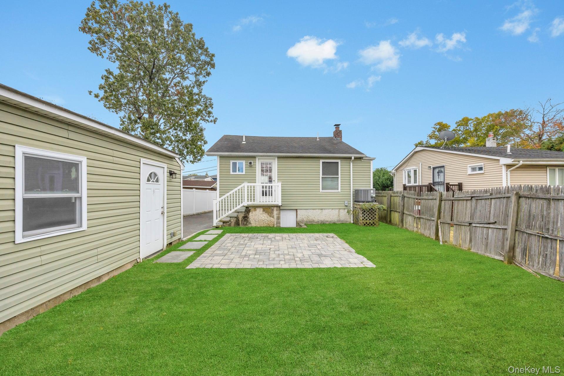 21 Ireland Place Copiague, NY 11726 - Photo 7 of 26 a view of backyard of house with wooden deck and seating