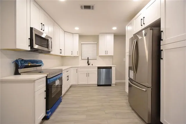 a kitchen with stainless steel appliances a refrigerator sink and microwave