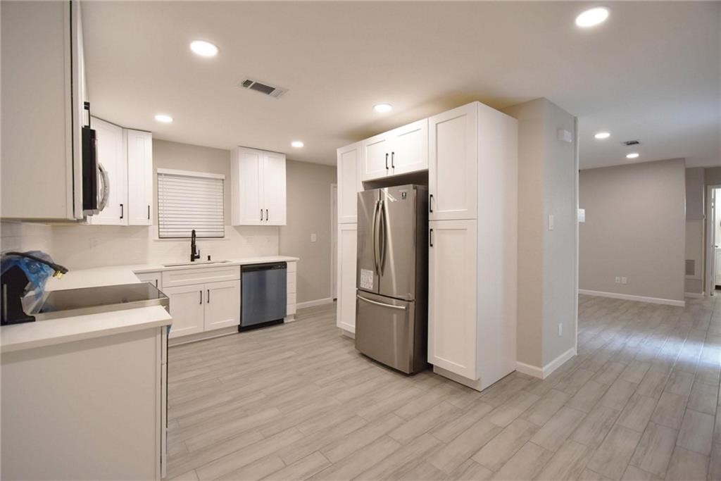 8600 Fathom Circle, Unit 1408 Austin, TX 78750 - Photo 2 of 17 a kitchen with a refrigerator sink and cabinets