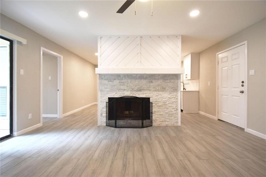 8600 Fathom Circle, Unit 1408 Austin, TX 78750 - Photo 5 of 17 an empty room with wooden floor and fireplace