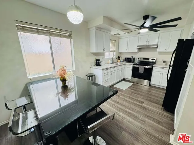 a kitchen with kitchen island white cabinets and stainless steel appliances