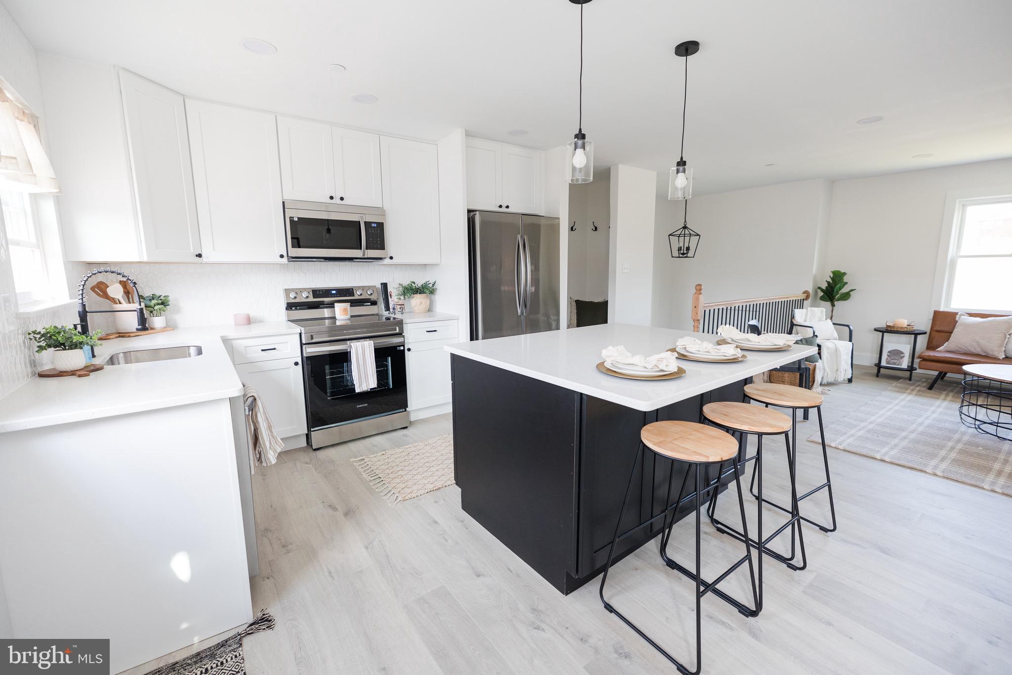 6 Valley Bend Road Westminster, MD 21157 - Photo 18 of 41 a kitchen with stainless steel appliances kitchen island granite countertop a sink a stove a refrigerator and island with wooden floor