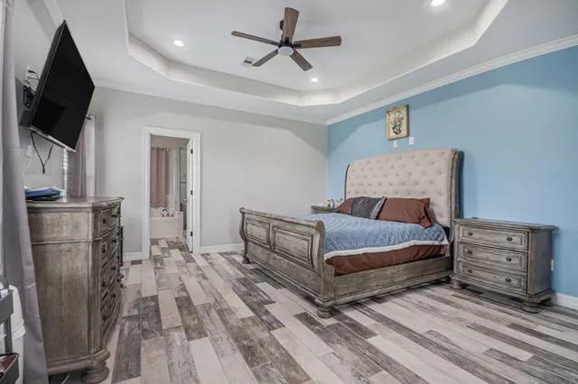 a bedroom with a bed a flat screen tv and dresser