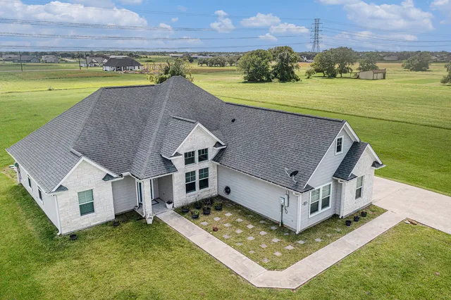 an aerial view of a house with a garden and lake view
