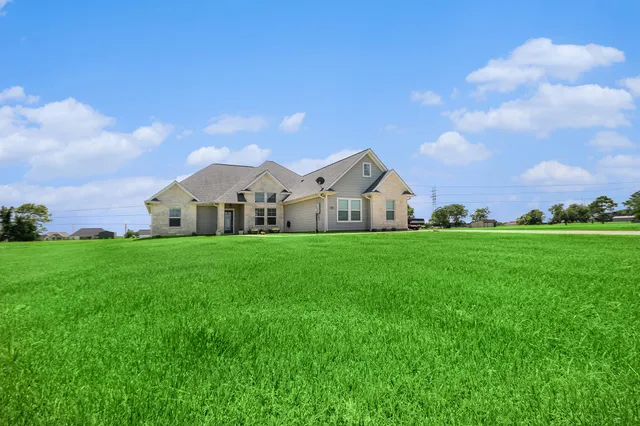 a view of white house with garden and wooden fence