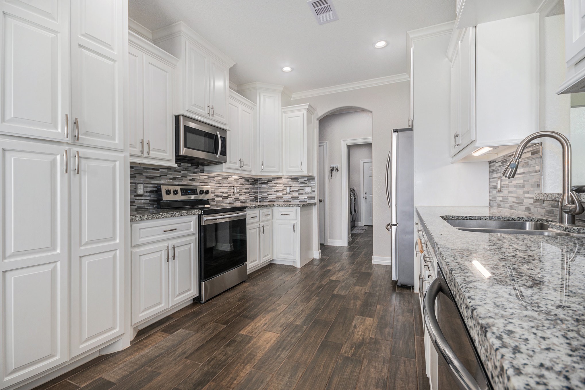 489 Sunset Trail Angleton, TX 77515 - Photo 6 of 39 a kitchen with stainless steel appliances granite countertop a stove top oven a sink and white cabinets