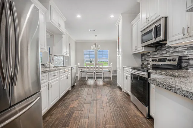 a kitchen with stainless steel appliances a stove top oven a sink and a refrigerator