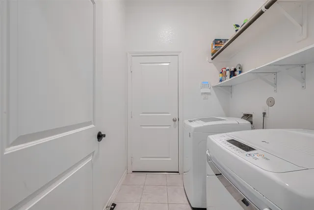 a view of washer and dryer with bathtub in bathroom