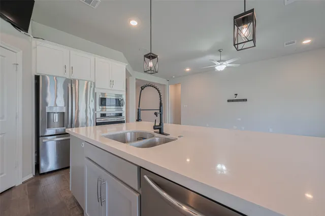 a kitchen with stainless steel appliances a sink a refrigerator and a stove