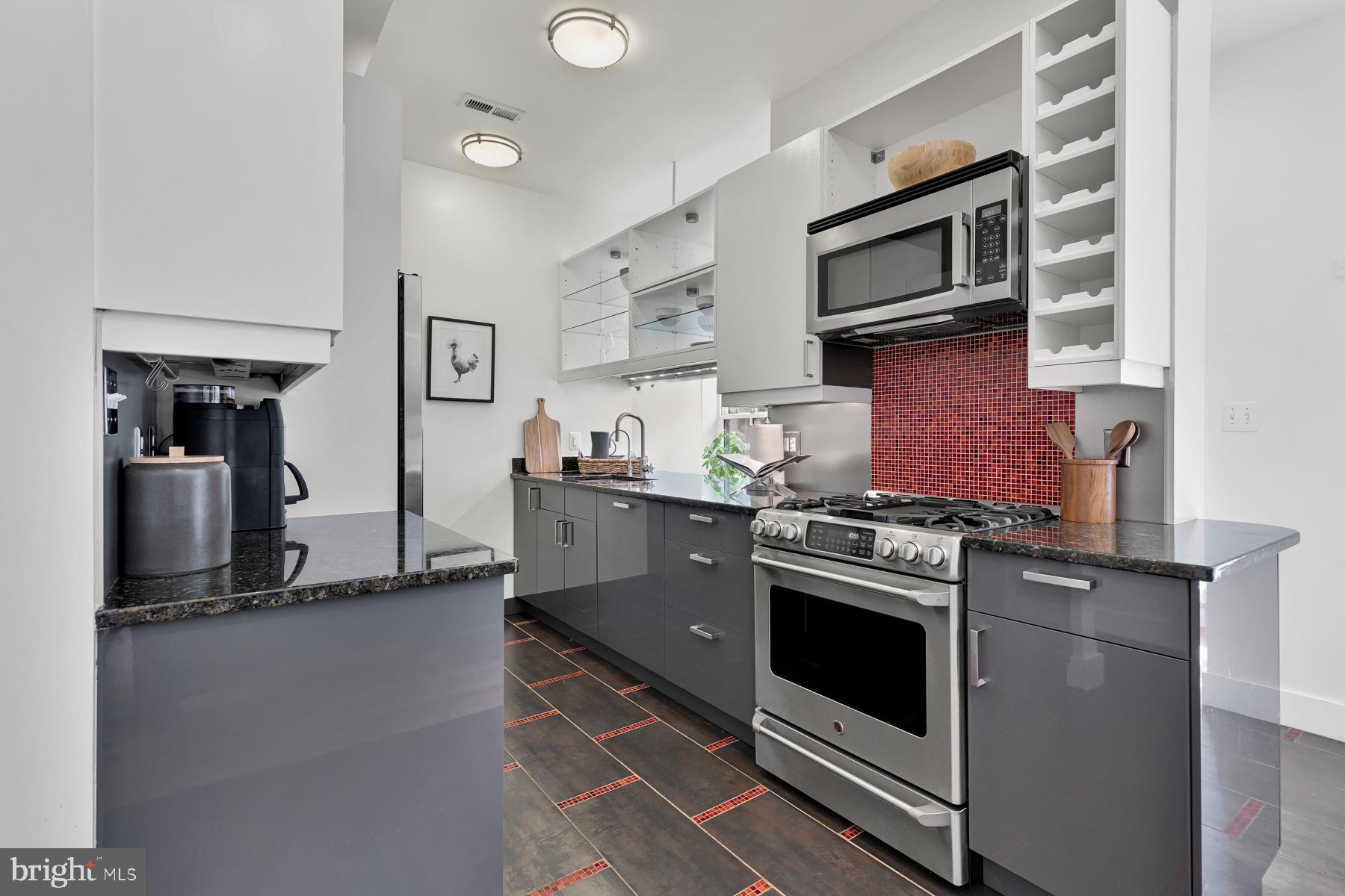 801 Q Street Northwest, Unit 1 Washington, DC 20001 - Photo 17 of 39 a kitchen with stainless steel appliances granite countertop a stove top oven a sink dishwasher and white cabinets