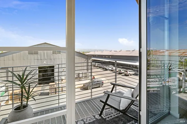 a view of a balcony with a potted plant and wooden floor
