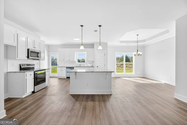 a large kitchen with cabinets wooden floor and stainless steel appliances