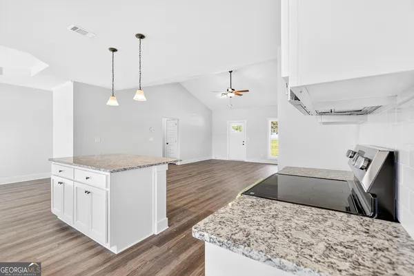 a kitchen with stainless steel appliances granite countertop a sink a stove and a wooden floors