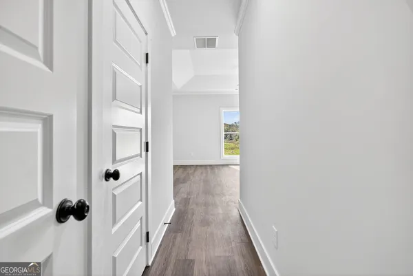 a view of a hallway with wooden floor and staircase