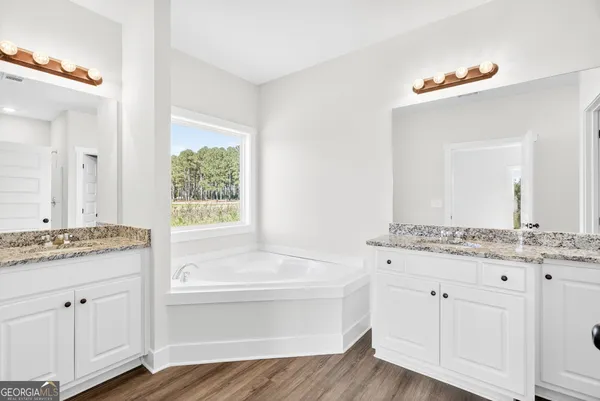 a bathroom with a granite countertop sink mirror and bathtub