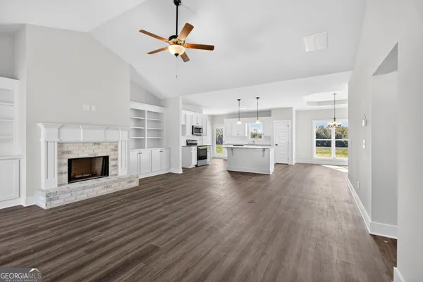 a view of a room with kitchen and fireplace wooden floor