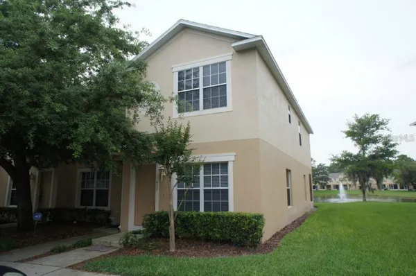 a view of house with a yard and potted plants