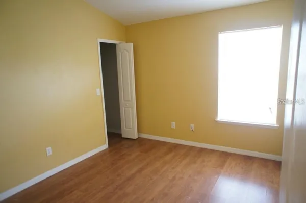 an empty room with wooden floor and a window