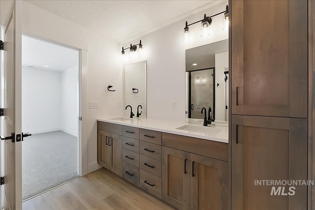 776 South Calhoun Lane Star, ID 83669 - Photo 29 of 49 Dual vanity featuring wood-finish cabinetry, white countertops, and matte black fixtures