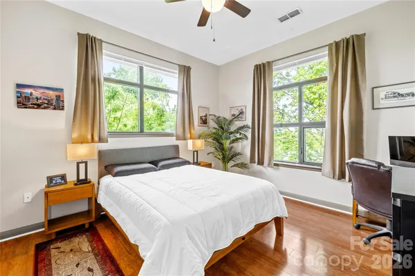 a bedroom with a bed a chair and a large window