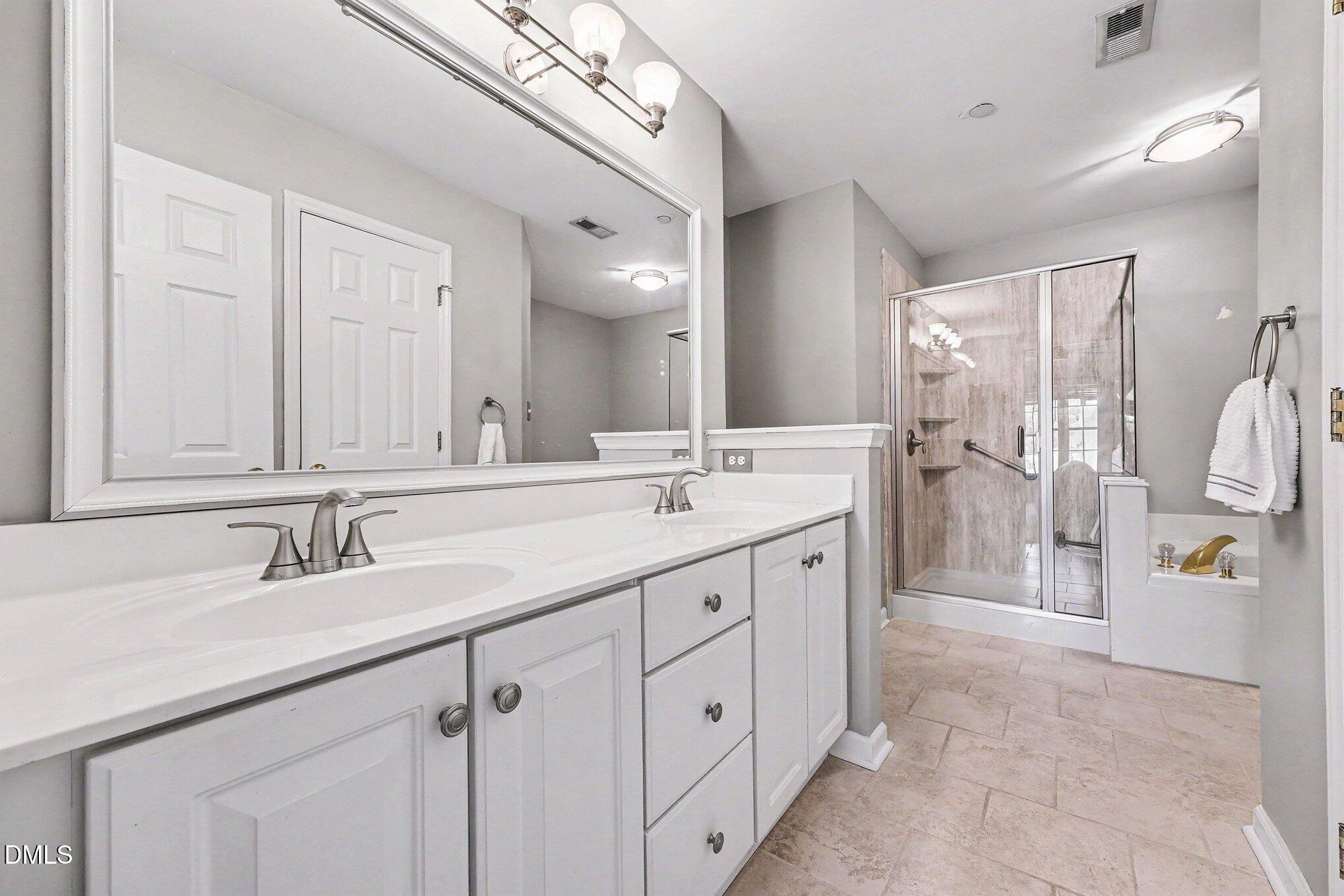 132 Springfork Drive Cary, NC 27513 - Photo 22 of 28 a spacious bathroom with a double vanity sink double and mirror